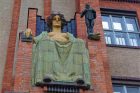 Alegorická postava ženy podpírá bronzovou sochu chlapce, který symbolizuje Salon republiky