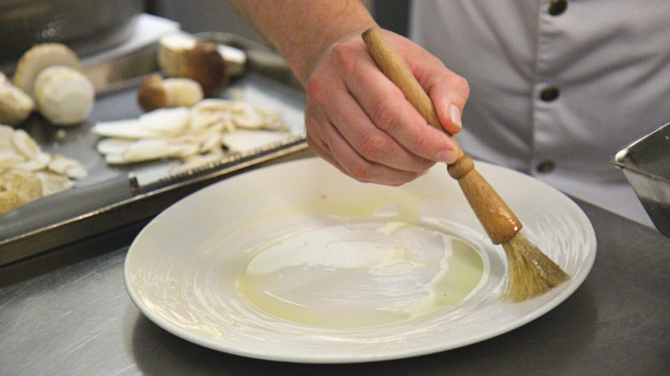 Na talíř, na kterém budeme servírovat, naneseme silnější vrstvu přepuštěného másla 