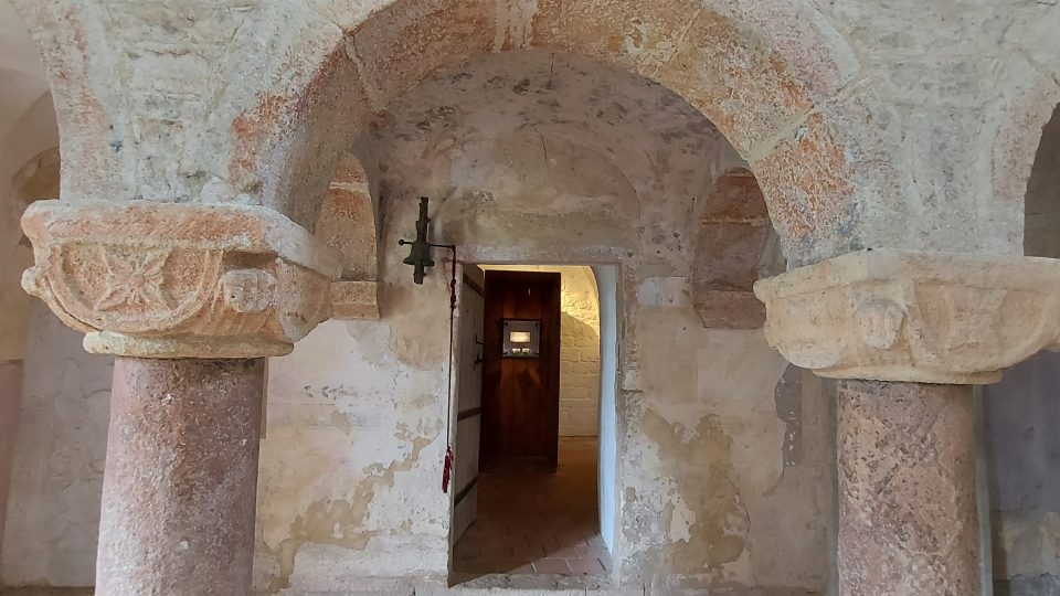 Podpěrné sloupy románské tribuny a vchod do sakristie, kde je nově umístěná zajímavá  výstava