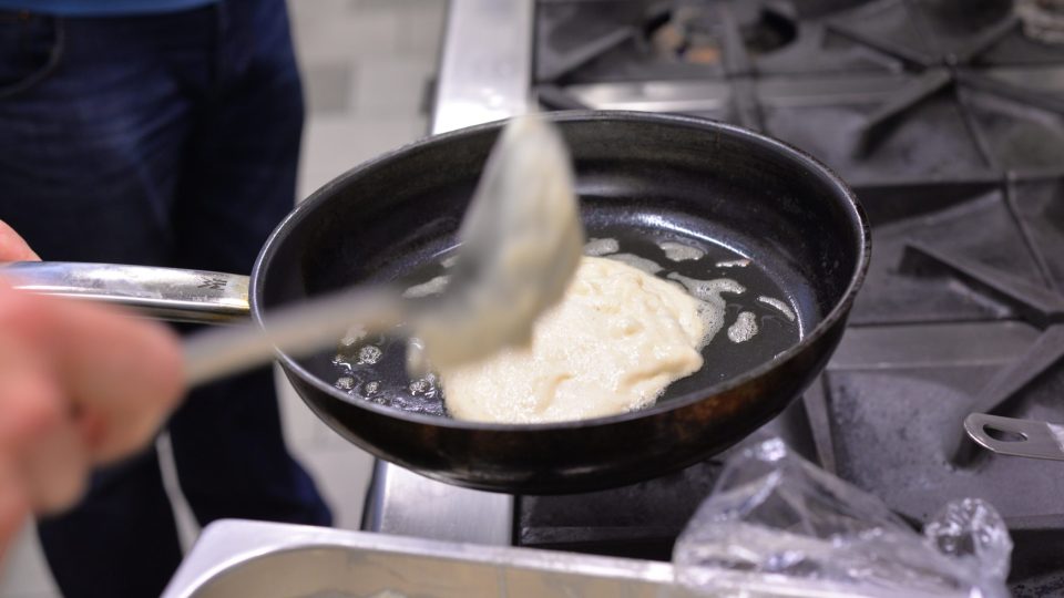 Na rozehřáté pánvičce si rozehřejeme máslo, nalijeme těsto a placku z jedné strany opečeme