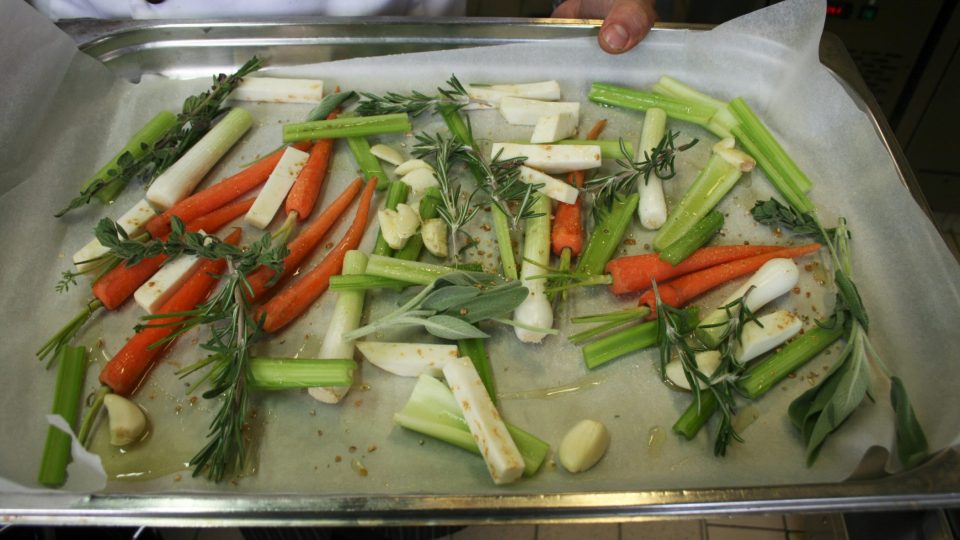 Na pekáč dáme pečící papír a vyskládáme zeleninu (baby karotka, jarní cibulka, překrájený řapíkatý celer, petržel, pastinák)