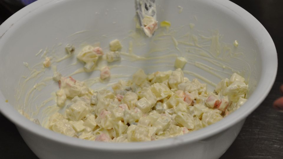 Zeleninu i brambory smícháme v míse, přidáme nakrájená vařená vejce, na kostičky nakrájené nakládané okurky, majonézu i zakysanou smetanu a promícháme