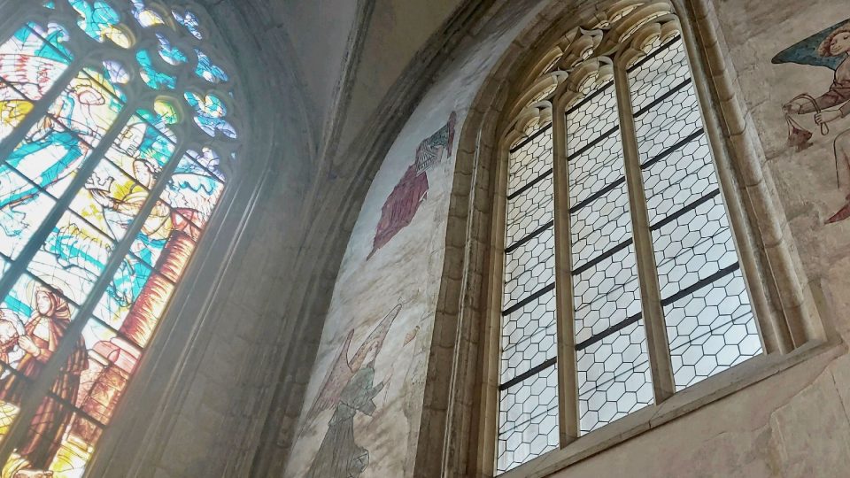 Moderně pojatá vitráž sv. Anežky České z roku 2014 vedle původních gotických fresek