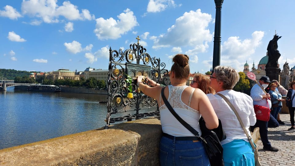 Lidé se na Karlově mostě ve velkém počtu zastavují, aby uctili památku sv. Jana Nepomuckého. Věří, že pokud se basreliéfu dotknou, budou mít štěstí