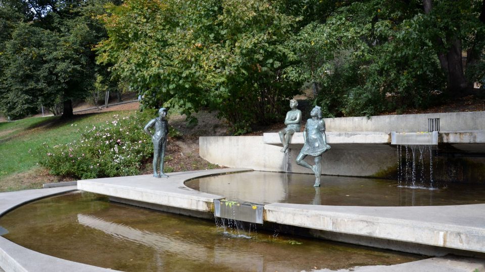 Kaskádovitá fontána a na ní tři plastiky dětí