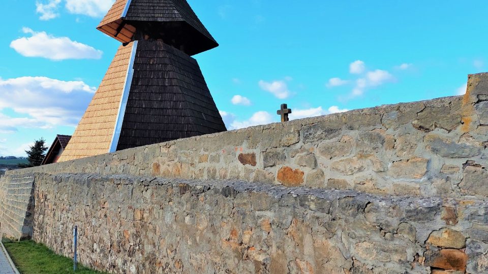 Šestibokou roubenou zvonici chrání historická zeď, kterou místní opravili