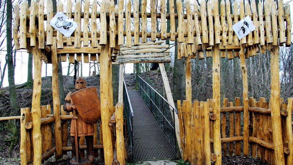 Stylizovaný padací most u parkoviště slouží jako vstup do bývalého hradního areálu s dřevěnou rozhlednou  