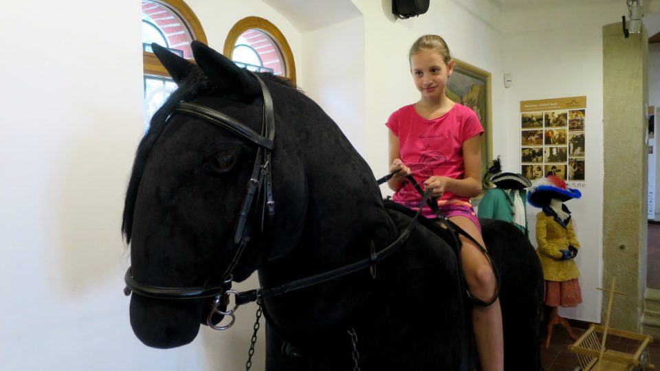 Největší plyšový kůň v Česku pod sedlem návštěvnice Interaktivního muzea starokladrubského koně ve Slatiňanech