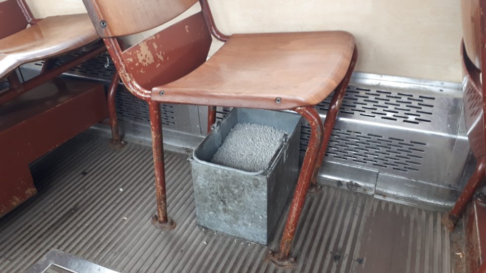 Nádoba s pískem pod sedačkou se v tramvaji používá dosud
