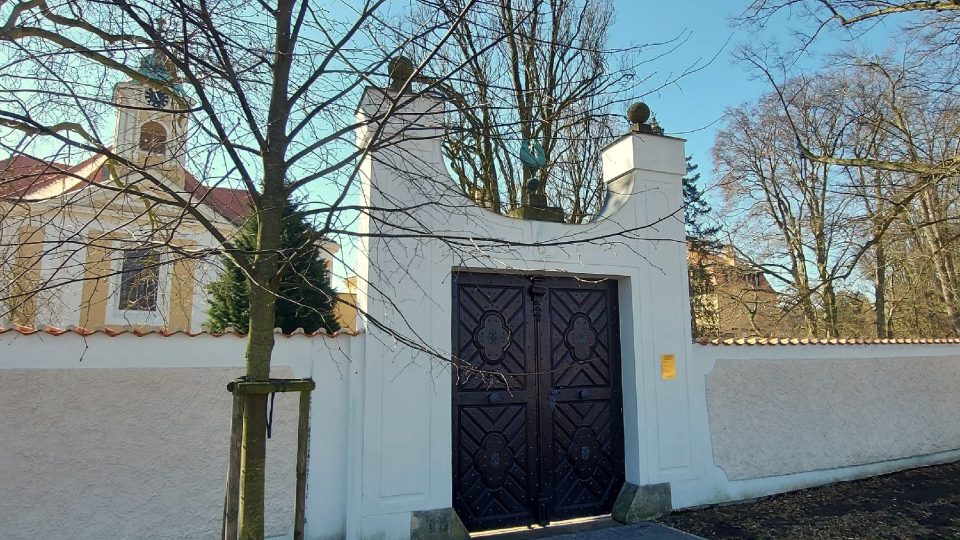 Vstup do kostela je bránou v zámecké obvodové zdi s úpravou od architekta Jože Plečnika