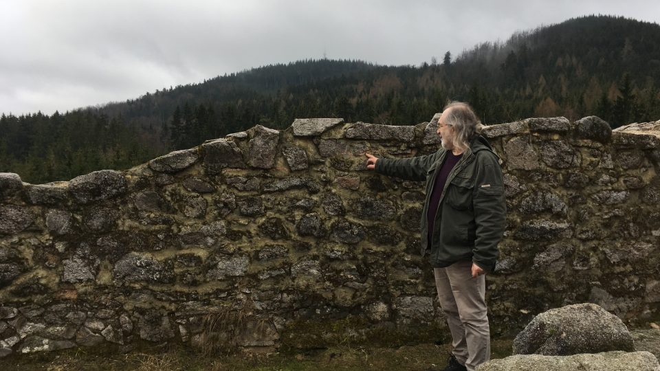 Archeolog Jiří Klsák ukazuje výšku, kde je zachováno původní zdivo kostela.JPG