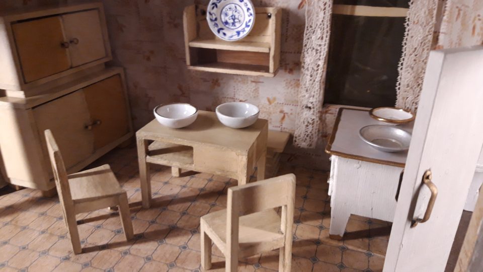 Domečky pro panenky mívaly i zařízenou kuchyňku. Nechybělo ani nádobí, příbory nebo záclonky